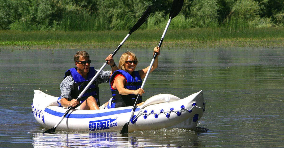 Two kayakers tandem paddle a Sea Eagle 330 Sport Inflatable Kayak.