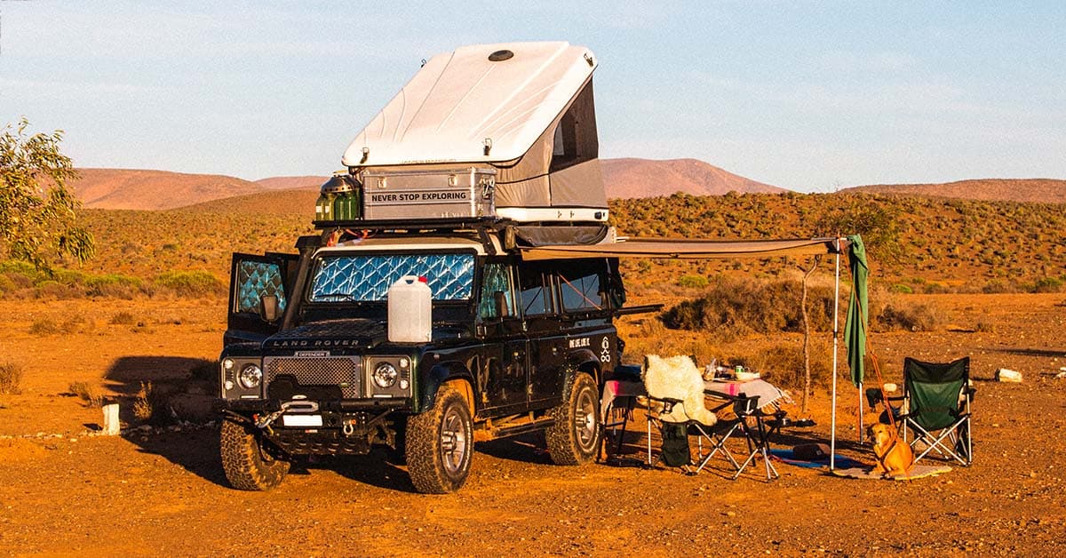Camping with a hard shell roof top tent on top of a Land Rover Defender.