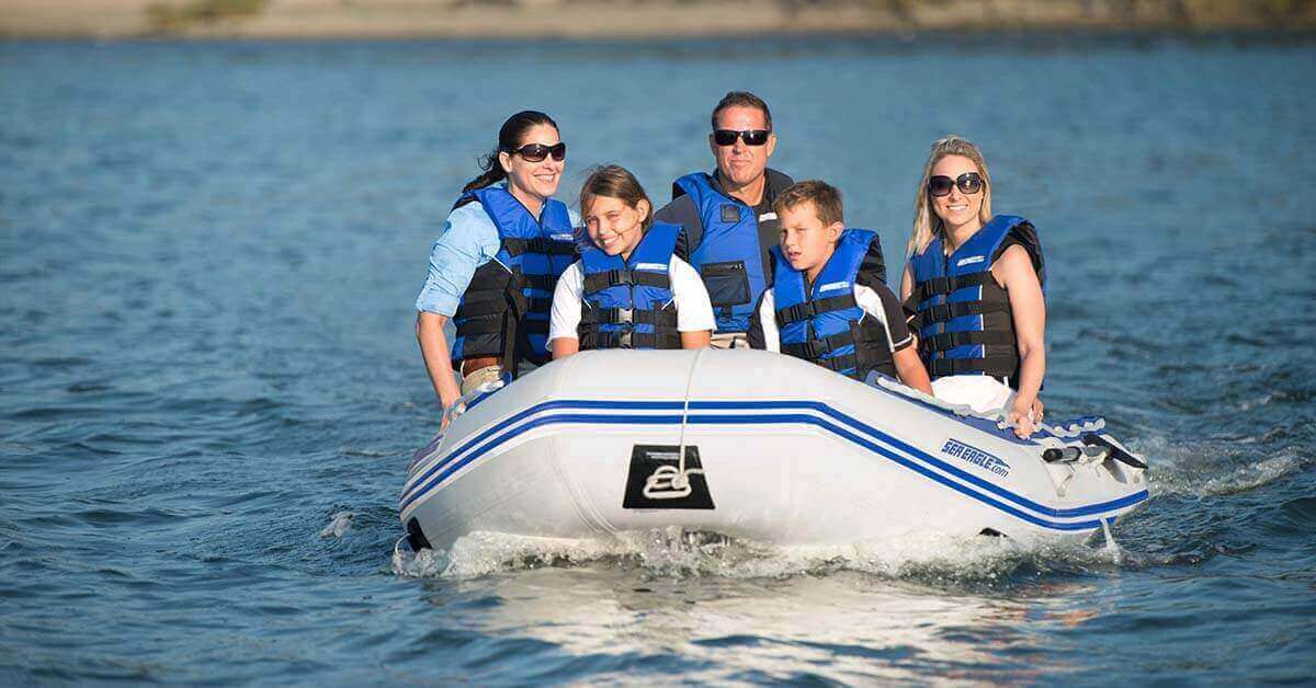 A Sea Eagle 12’6″ Sport Runabout Inflatable Boat with 5 passengers having fun on a bay.