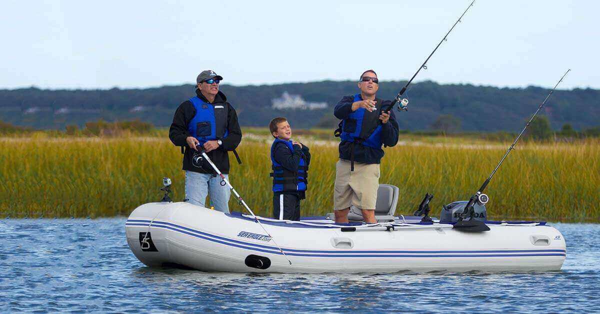 Two men and a boy fishing in a marsh from a Sea Eagle 14′ Sport Runabout Inflatable Boat.