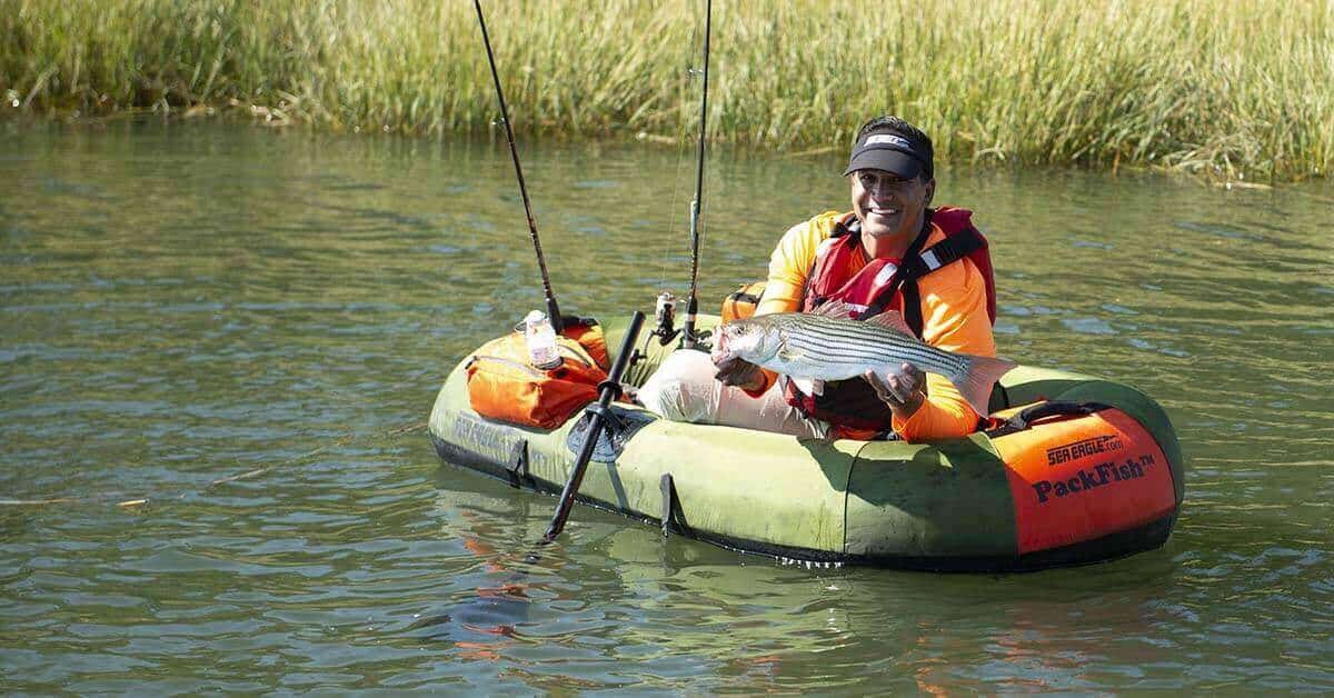 Fisherman showing off a catch made from a Sea Eagle PackFish7 inflatable boat.