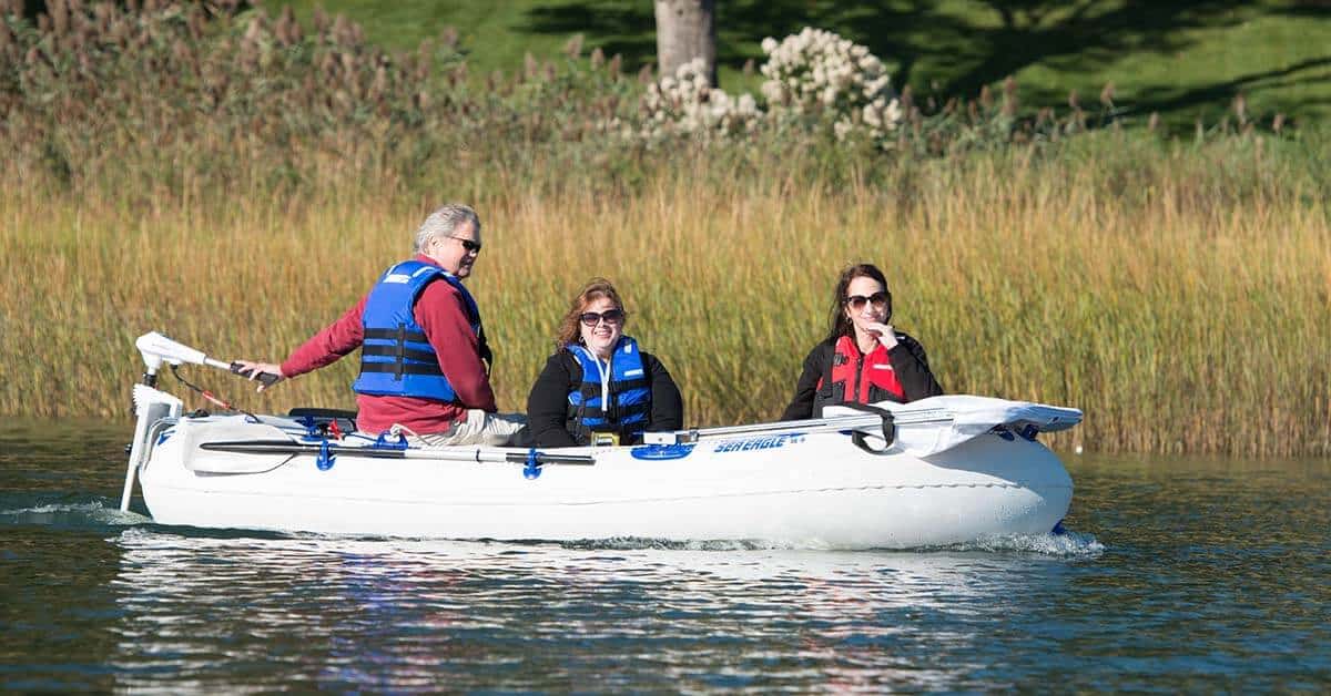 Three people out having fun on a recreational outing in a Sea Eagle 9 Inflatable Boat.