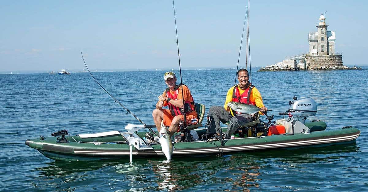 Two fishermen showing off their prize catches from a Sea Eagle FishSkiff 16 Inflatable Fishing Boat.