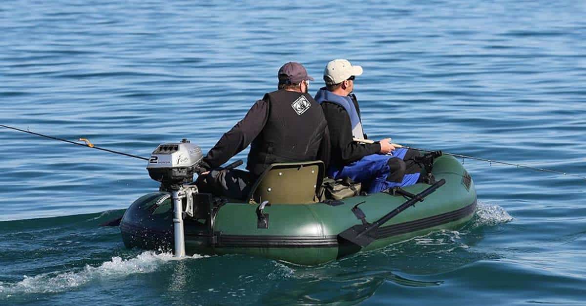 Two fishermen in a Sea Eagle Stealth Stalker 10 Inflatable Fishing Boat motoring across a lake using a 2HP Honda outboard motor.