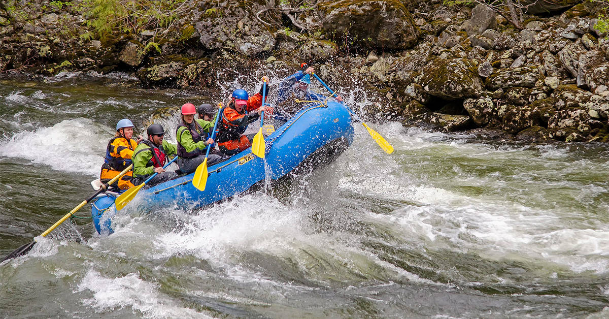 An NRS oar/paddle combo raft on a whitewater river.