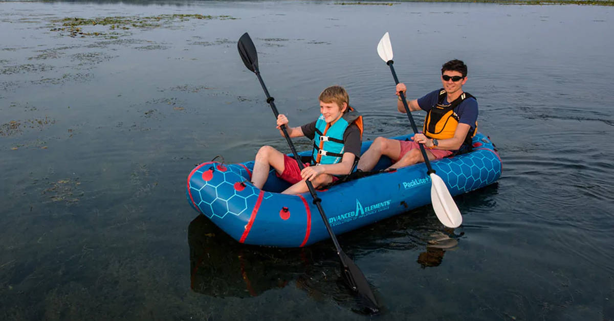 Two paddlers in an Advanced Elements Packlite+ XL Packraft on a remote lake.
