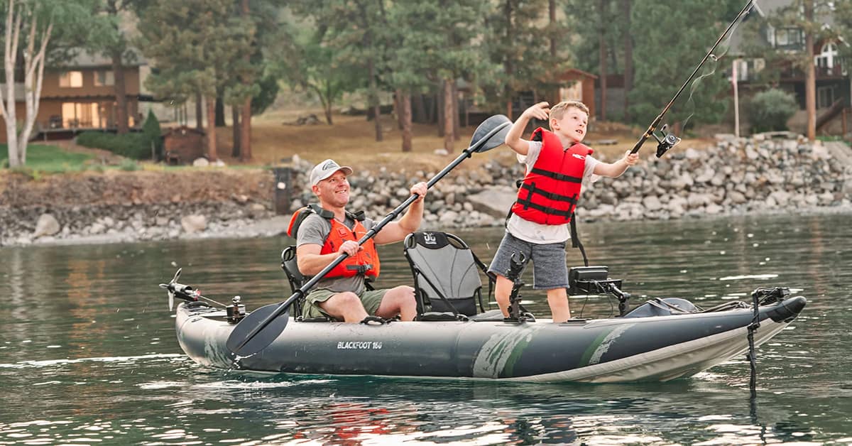 A father and son fishing on a lake from a Aquaglide Blackfoot Angler 160 Tandem inflatable kayak.
