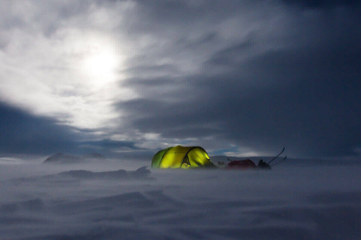 A 4-season tent set up on a snowy landscape in winter.