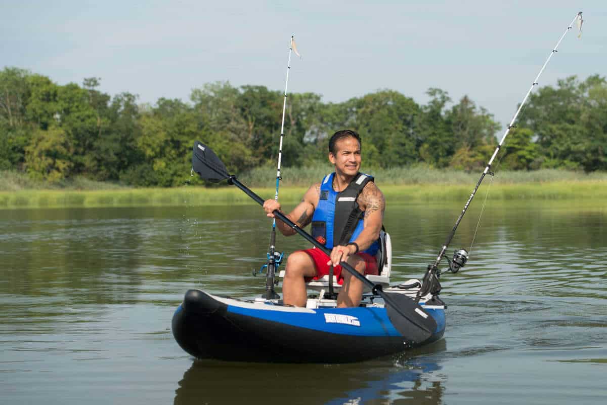 A fisherman paddles a 300x Explorer on a calm lake.