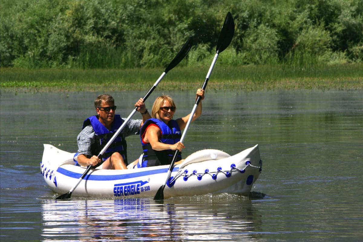 Two kayakers tandem paddling a Sea Eagle 330 Sport.