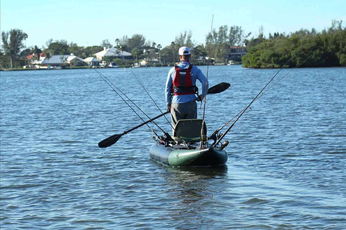A fisherman stands while paddling a Sea Eagle 350fx Fishing Explorer.