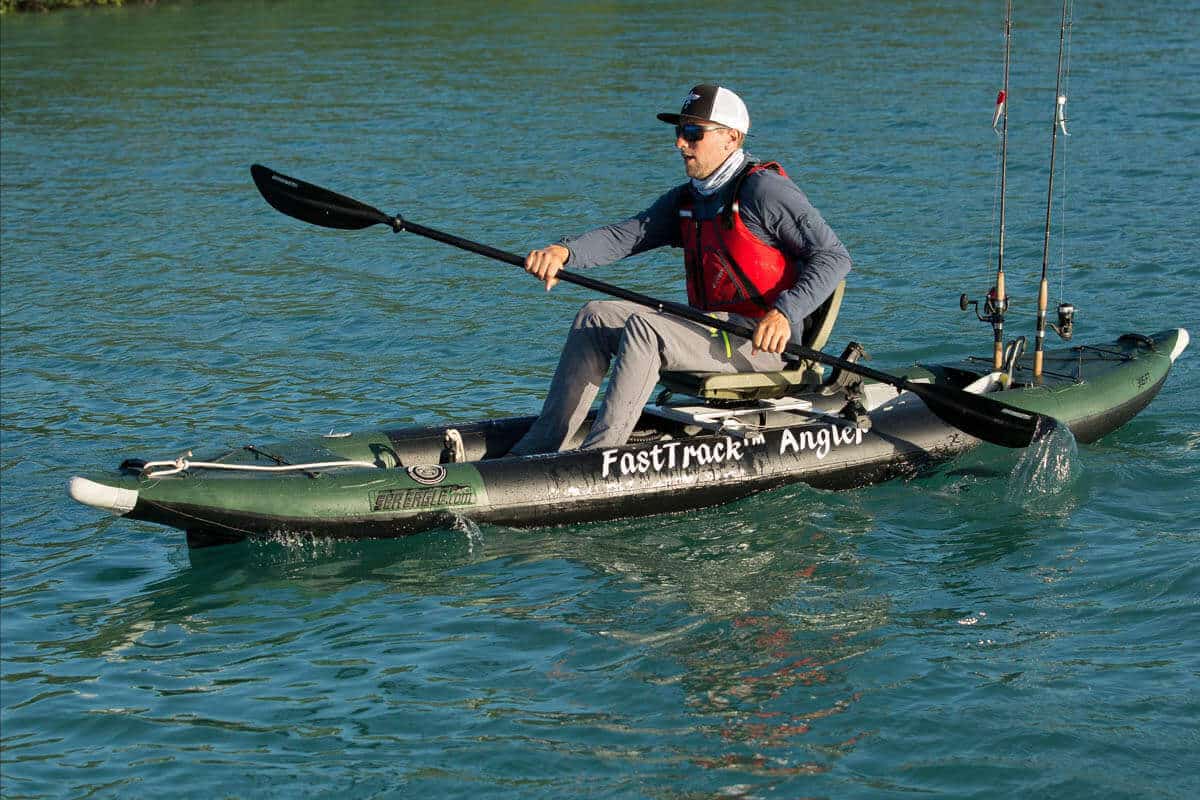 A fisherman sits in a swivel seat and paddles a Sea Eagle 385fta FastTrack Angler.