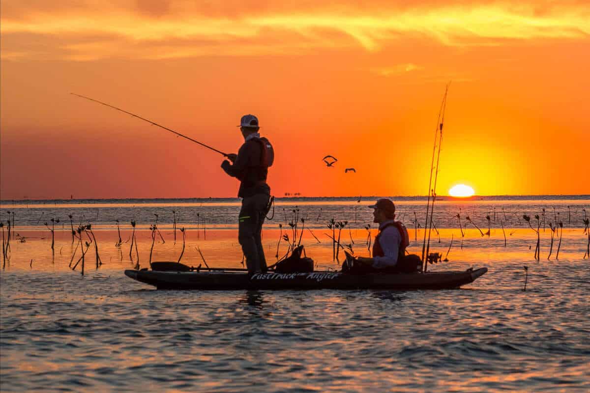Two fishermen in a Sea Eagle 385fta FastTrack Angler inflatable kayak at sunset.
