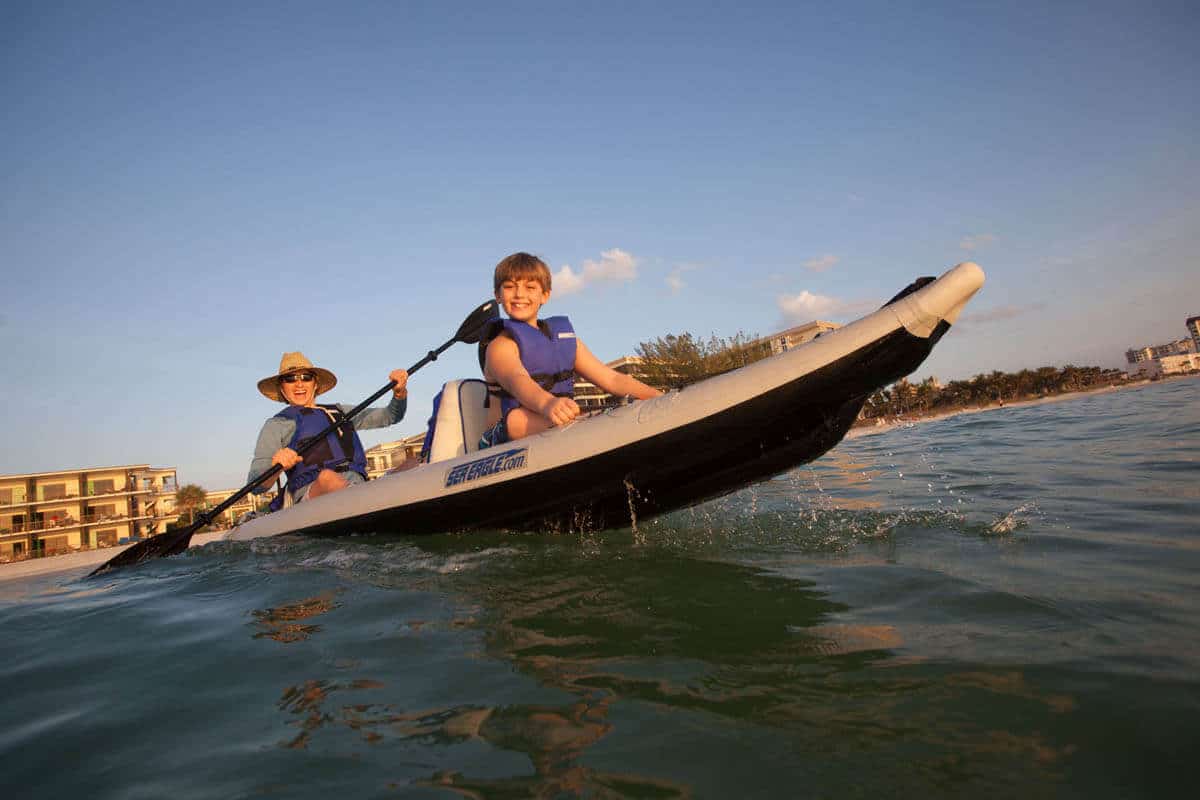 A parent paddles a 385 FastTrack with their son in the bow of the kayak.