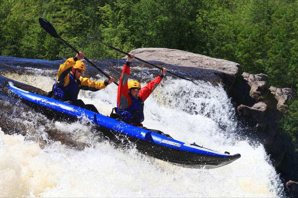 Two kayakers extreme kayaking over a waterfall in a Sea Eagle 420x.