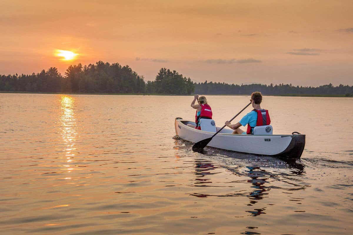 A couple out for a romantic paddle in a Sea Eagle TC16 Travel Canoe at sunset.