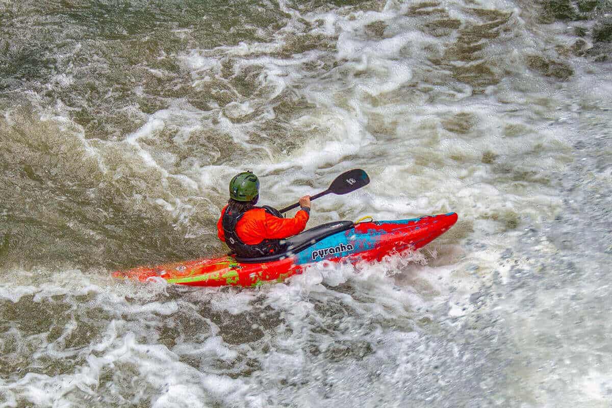 A paddler whitewater kayaking.