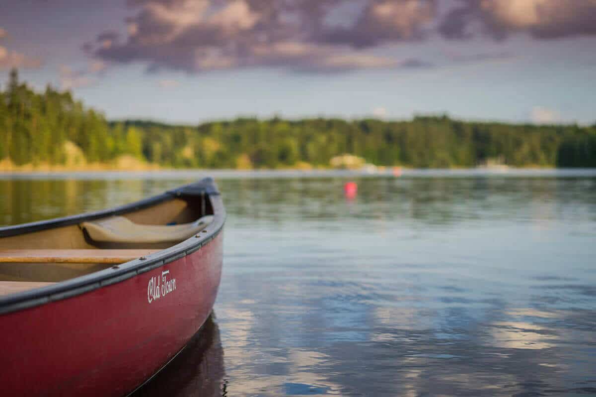 An Old Town canoe on a lake.