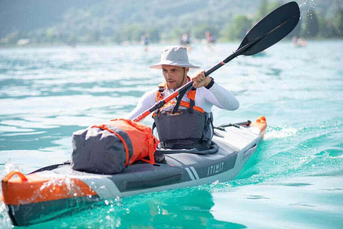 A Decathlon Itiwit X500 1-Person Inflatable Kayak being paddled on the ocean.