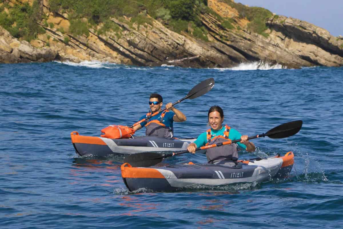 Kayakers paddling Decathlon Itiwit X500 1-Person Inflatable Touring Kayaks on the ocean.