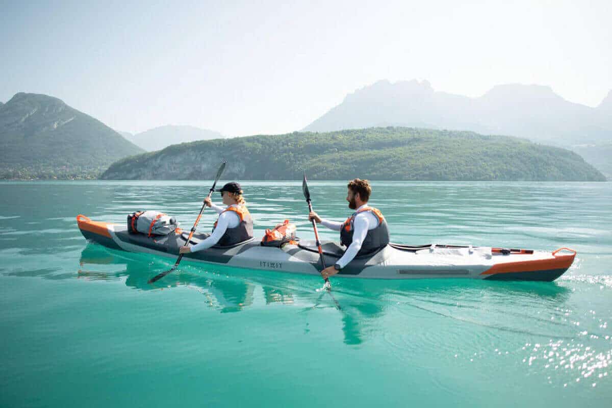A Decathlon Itiwit X500 2-Person Inflatable Touring Kayak being paddled on the ocean.